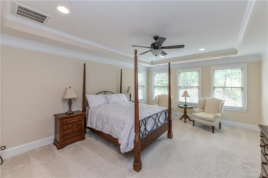 615 Pomegranate Place Fort Mill, SC 29708 - Photo 16 of 34 a spacious bedroom with a bed a chandelier and a window