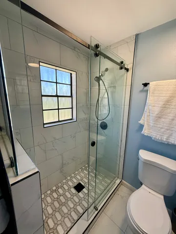 a bathroom with a toilet and shower