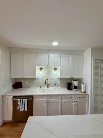 a kitchen with a sink a stove and cabinets