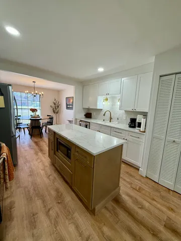 a kitchen with stainless steel appliances a sink a stove a refrigerator cabinets and a window