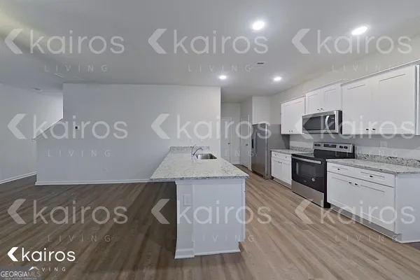 a kitchen with a refrigerator sink and cabinets