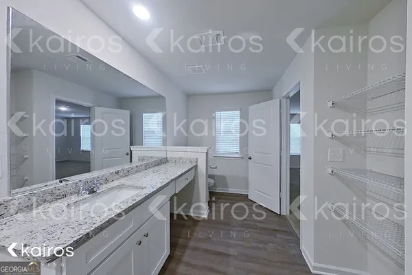 a spacious bathroom with a granite countertop sink a mirror and shower