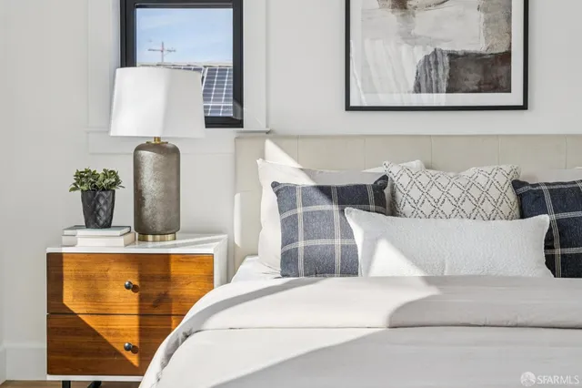 a bedroom with bed and paintings on the wall