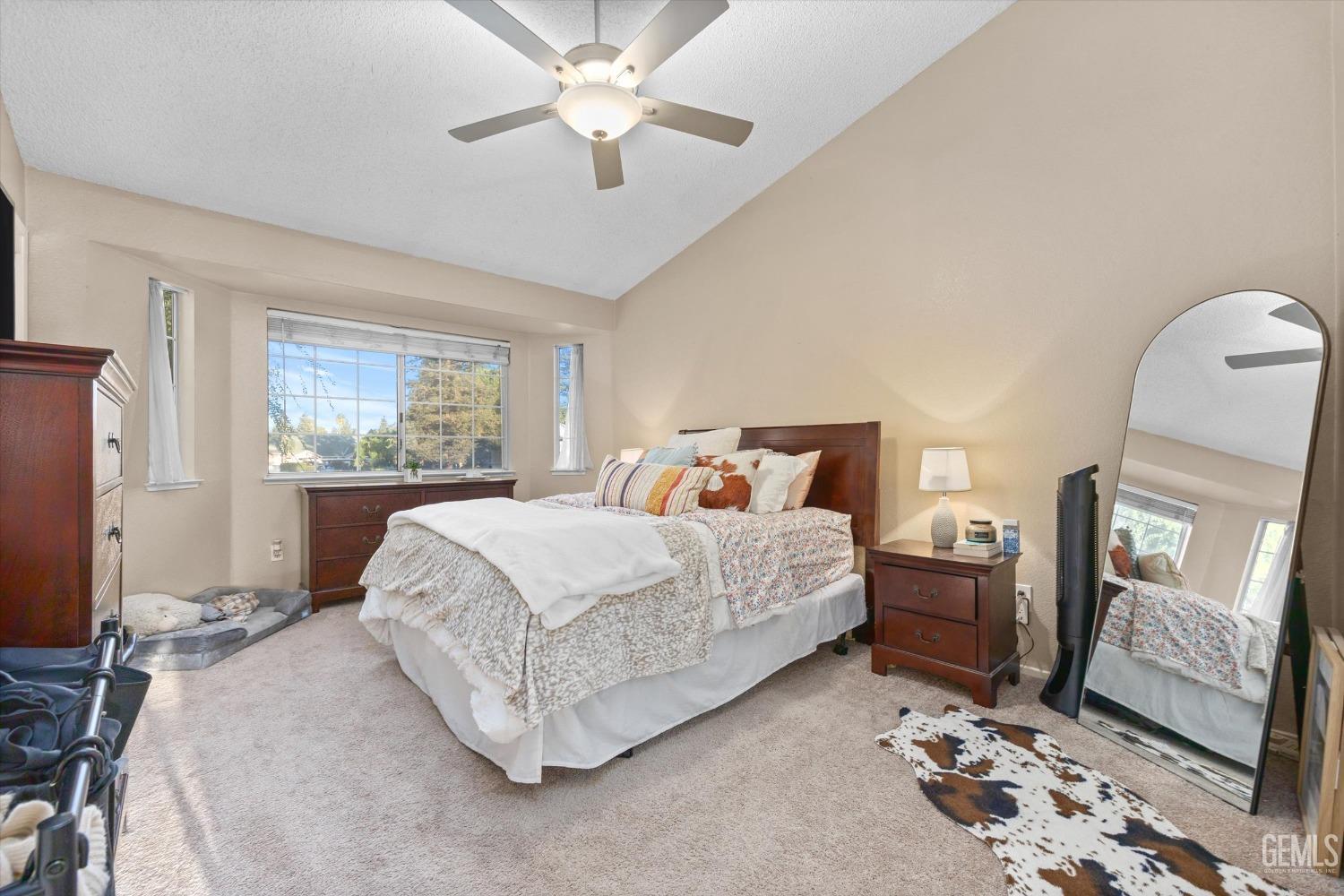 Undisclosed Address Bakersfield, CA 93311 - Photo 17 of 30 a spacious bedroom with a large bed and a chandelier
