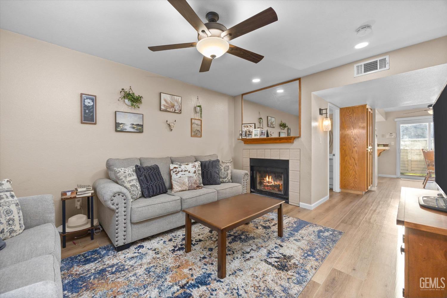 Undisclosed Address Bakersfield, CA 93311 - Photo 6 of 30 a living room with furniture a fireplace and a ceiling fan