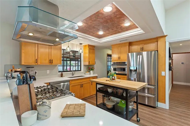 a kitchen with a sink appliances and wooden floor