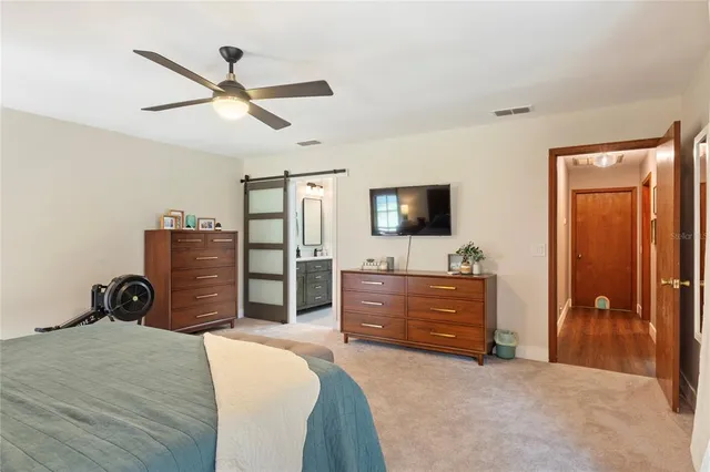 a spacious bedroom with a bed and a chandelier