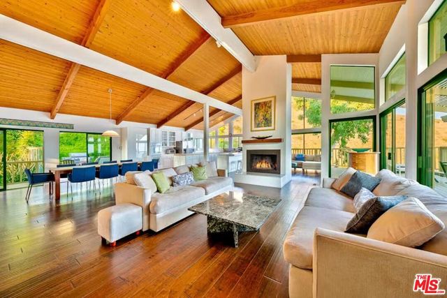 a living room with fireplace furniture and a large window