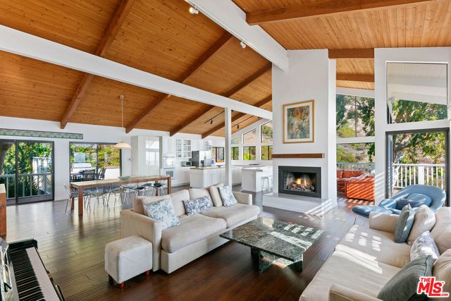 a living room with furniture fireplace and a large window