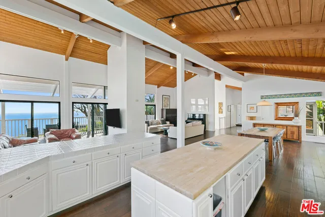 a hall with stainless steel appliances granite countertop a sink and cabinets