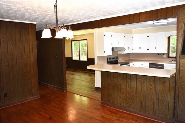 a kitchen with a sink cabinets and wooden floor