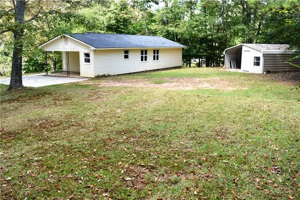 a view of a house with a yard and fence