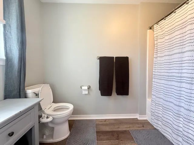 a bedroom with a bed and a flat tv screen on the dresser