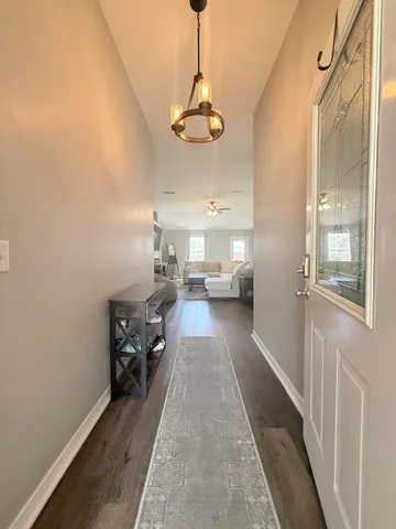 a kitchen with stainless steel appliances granite countertop a refrigerator a sink dishwasher a stove and a dining table with wooden floor