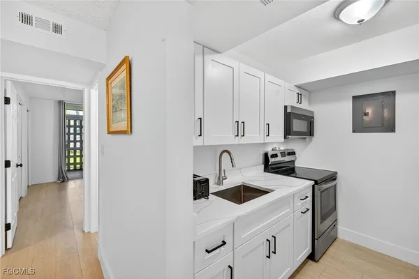 a kitchen with stainless steel appliances granite countertop a sink and a microwave