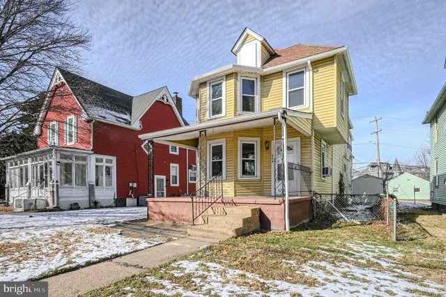 a view of a brick house with large windows and a yard