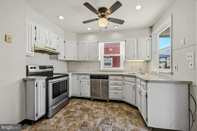 a kitchen with stainless steel appliances granite countertop a sink and cabinets