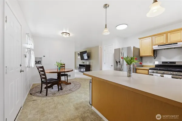a kitchen with kitchen island a dining table and chairs