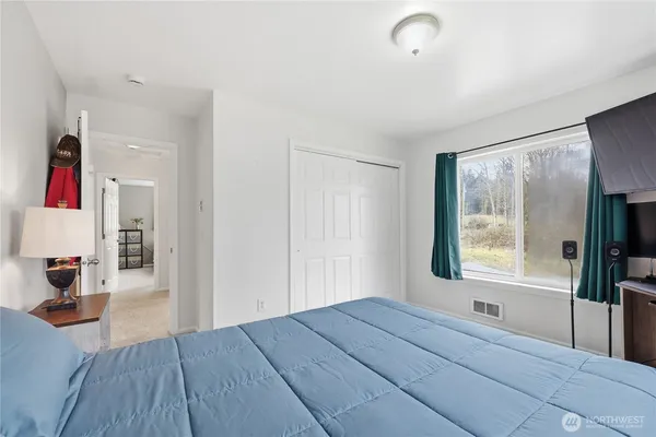 a bedroom with a bed and a large window