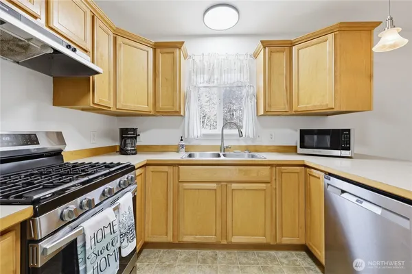 a kitchen with stainless steel appliances granite countertop a sink stove and cabinets