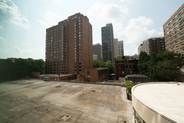 a view of outdoor space with building and trees in the background