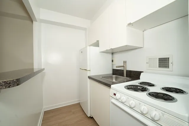 a white stove top oven sitting inside of a kitchen