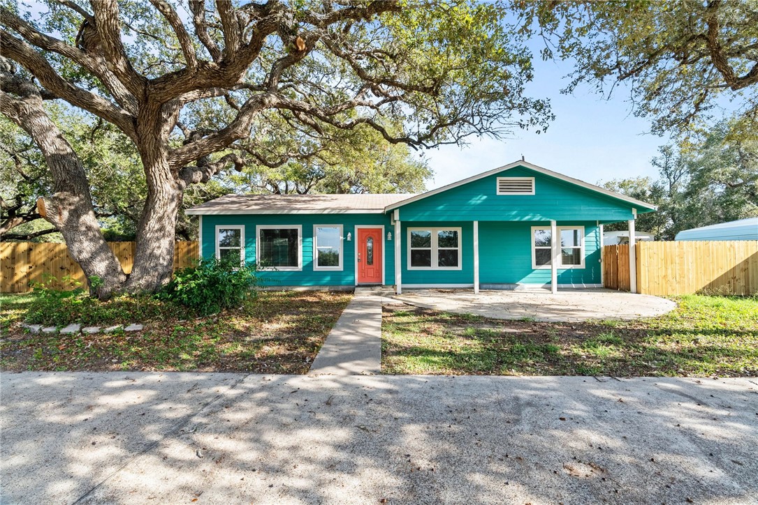 a view of a house with a yard and large tree