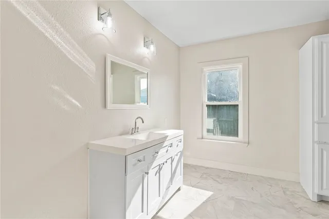 a bathroom with a sink a vanity and a window