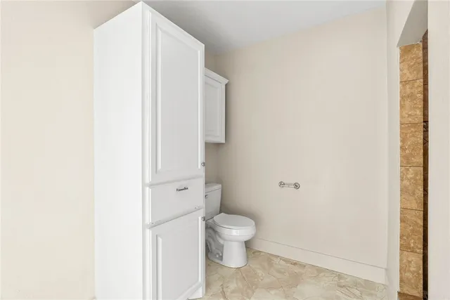 a white toilet sitting next to a shower