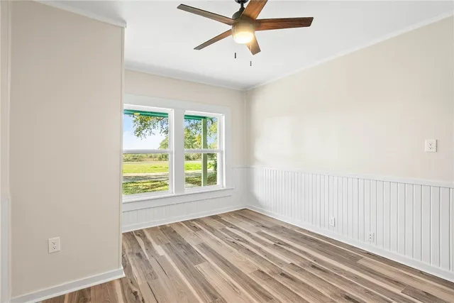 an empty room with a window and a ceiling fan