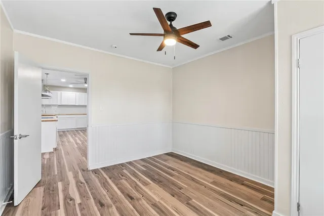a view of empty room with wooden floor