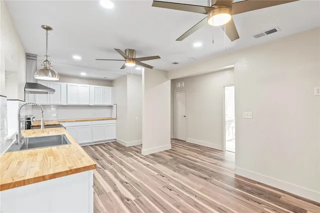 a room with wooden floor and ceiling fan