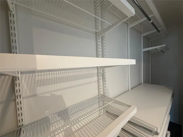 an empty room with windows and ceiling fan