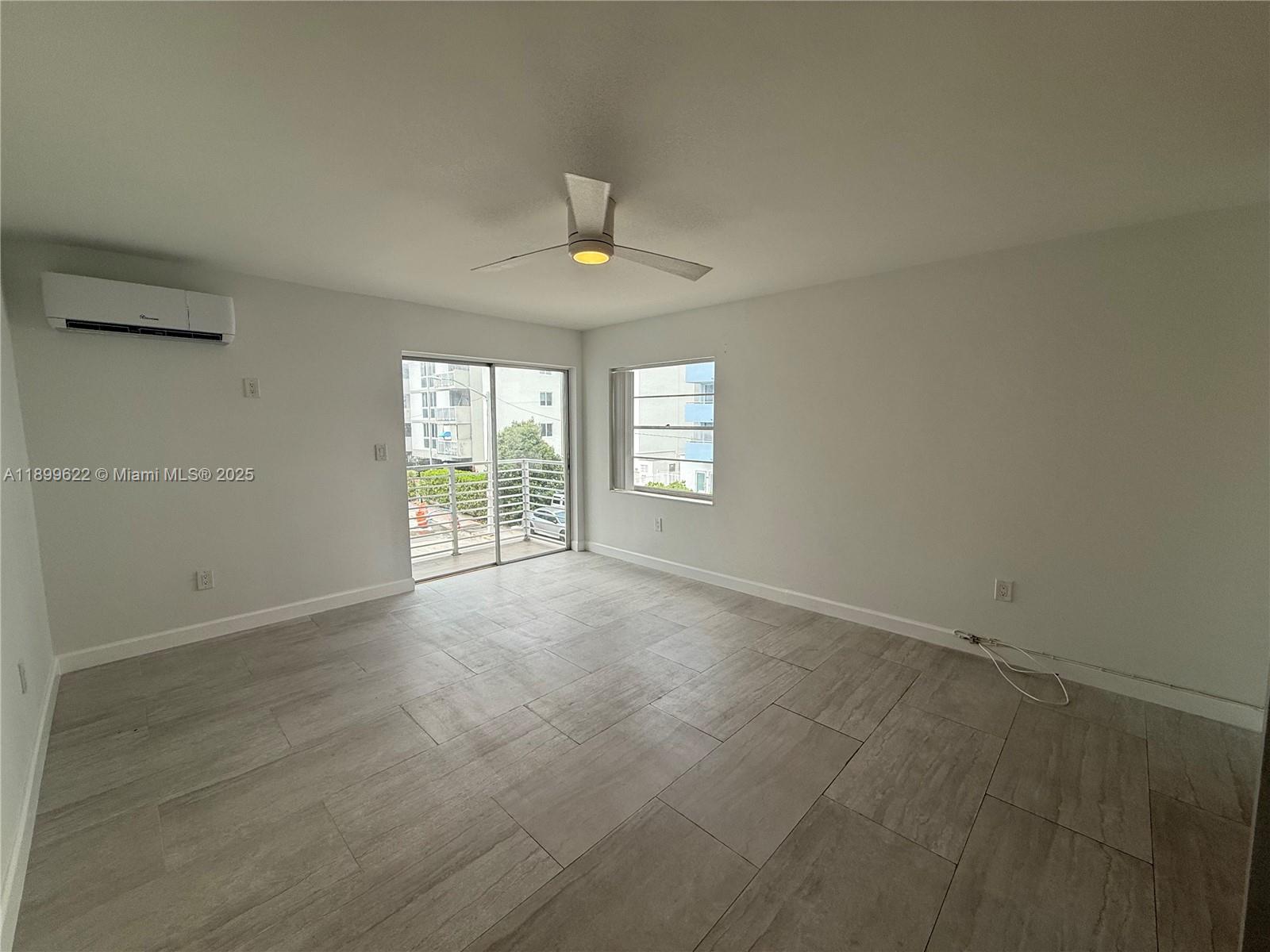 1441 Lincoln Road, Unit 317 Miami Beach, FL 33139 - Photo 25 of 31 en empty room with windows and chandelier fan