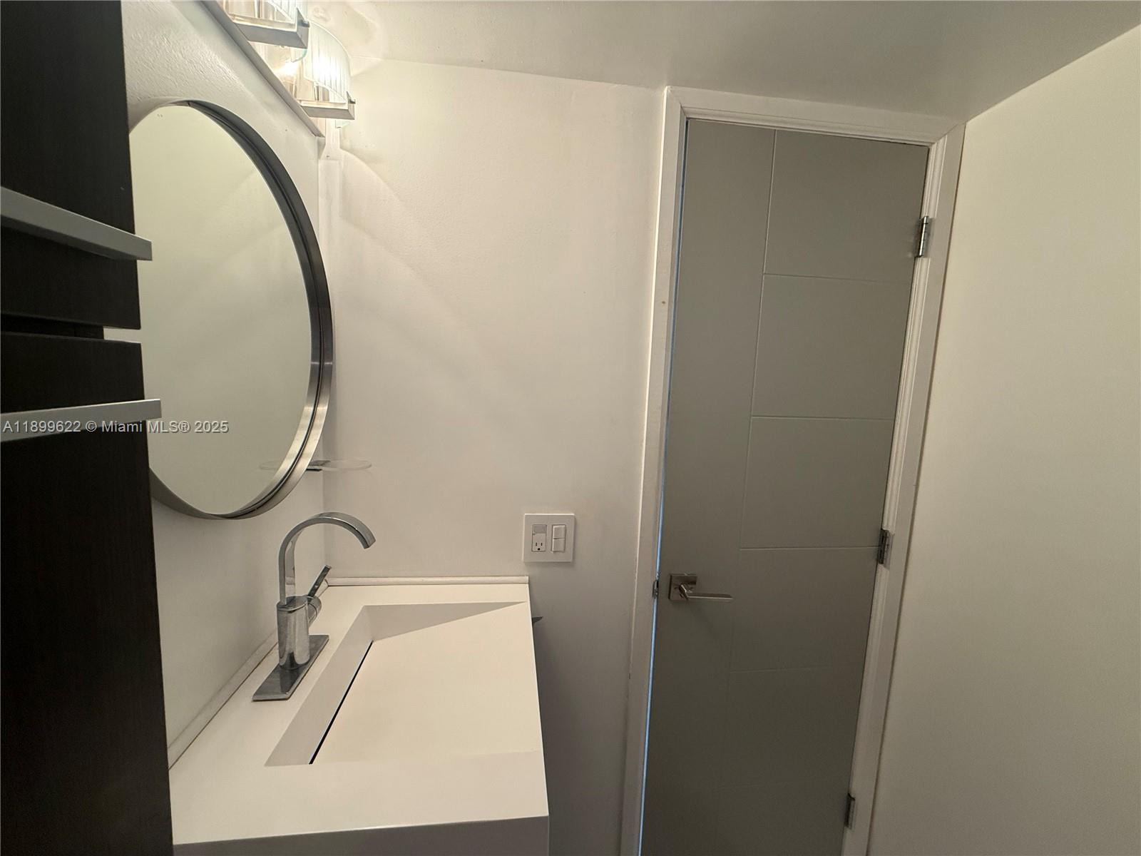 1441 Lincoln Road, Unit 317 Miami Beach, FL 33139 - Photo 8 of 31 a bathroom with a sink and a mirror