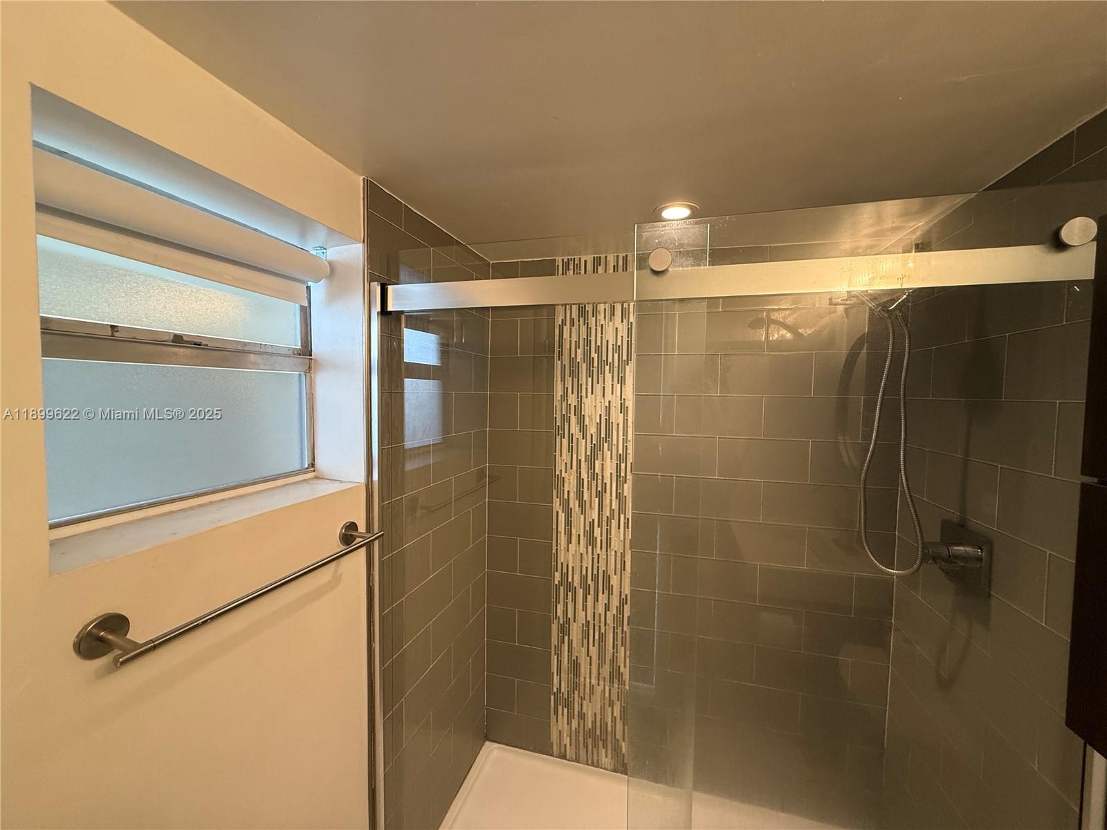 1441 Lincoln Road, Unit 317 Miami Beach, FL 33139 - Photo 9 of 31 a bathroom with a shower and a mirror