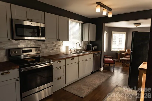 a kitchen with stainless steel appliances a stove sink microwave and cabinets