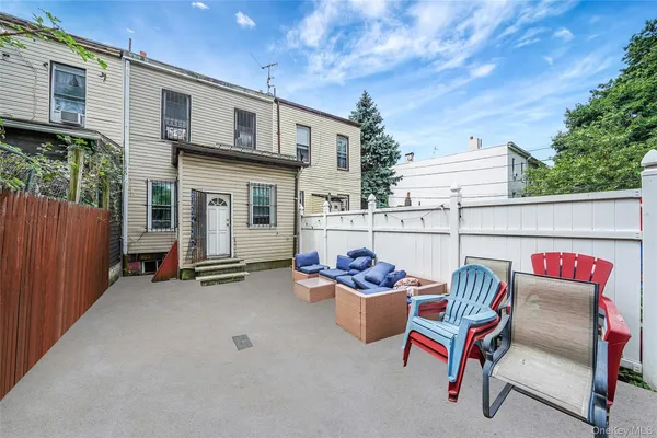 a view of a chairs and table in the back yard of the house