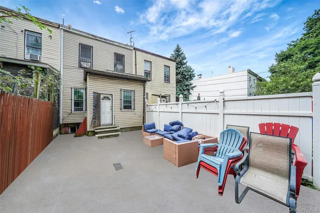 a view of a chairs and table in the back yard of the house