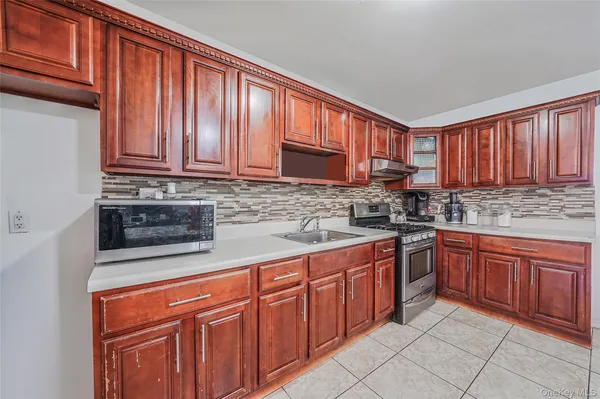 a kitchen with stainless steel appliances granite countertop wooden cabinets a stove top oven a sink and dishwasher