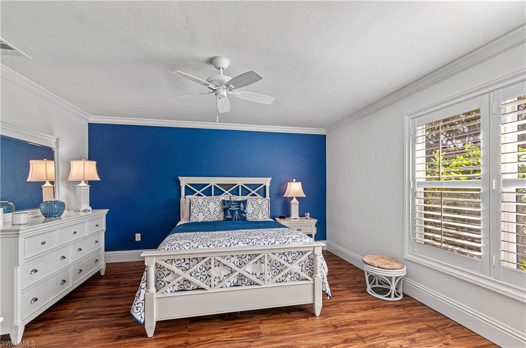 4022 Crayton Road Naples, FL 34103 - Photo 12 of 28 a bedroom with a bed and wooden floor