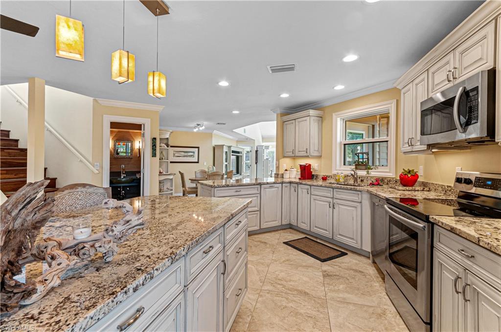 4022 Crayton Road Naples, FL 34103 - Photo 18 of 28 a kitchen with stainless steel appliances granite countertop a stove and cabinets