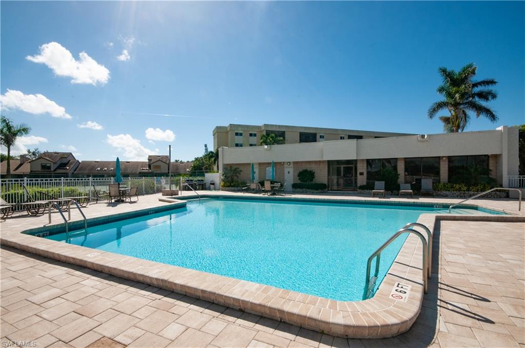 4022 Crayton Road Naples, FL 34103 - Photo 24 of 28 a view of a swimming pool with a lounge chair