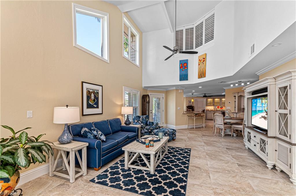 4022 Crayton Road Naples, FL 34103 - Photo 5 of 28 a living room with furniture a flat screen tv and a table