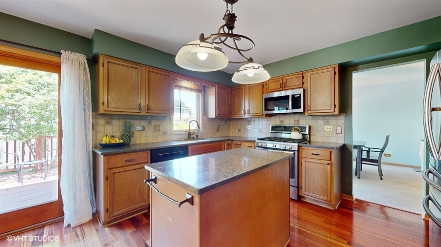 545 Abbey Road Bartlett, IL 60103 - Photo 11 of 28 a kitchen with stainless steel appliances granite countertop wooden floors a stove and a sink