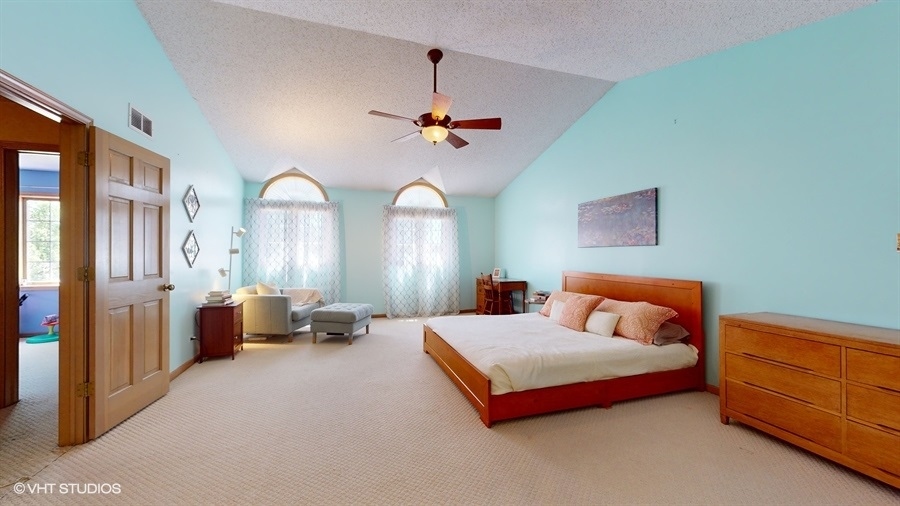 545 Abbey Road Bartlett, IL 60103 - Photo 16 of 28 a bed room with a bed and a chandelier
