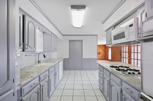 a kitchen with stainless steel appliances granite countertop a sink stove and cabinets