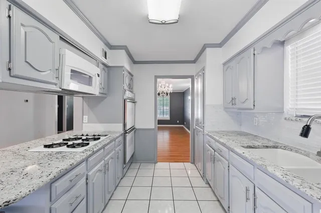 a view of an empty room and kitchen view