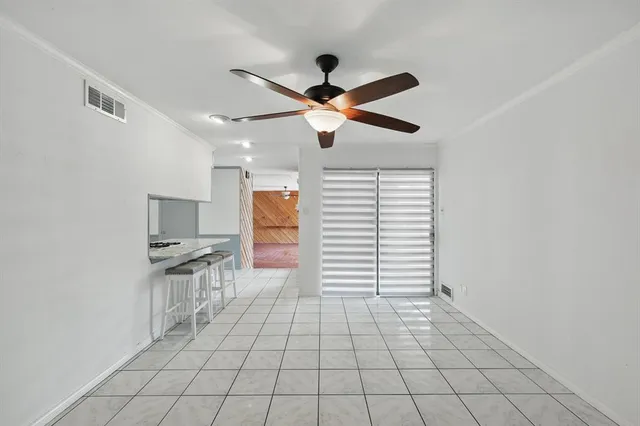 a view of empty room with window and ceiling fan