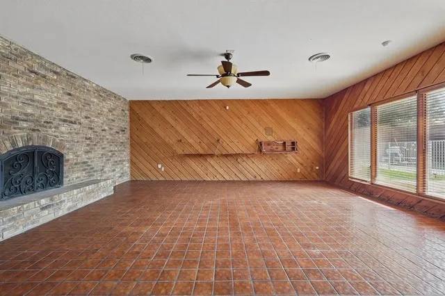 an empty room with windows and ceiling fan